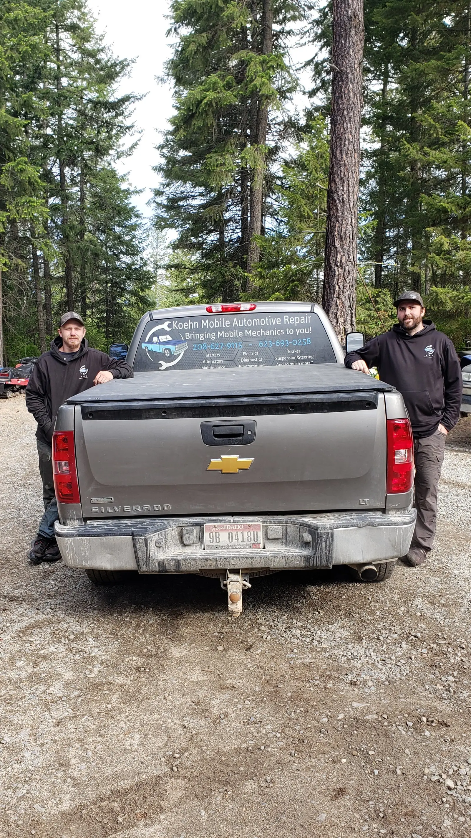 Two Koehn Mobile Automotive mechanics standing beside their service truck